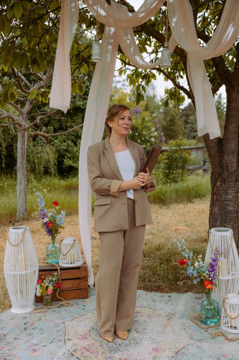 Brautpaar steht im Freien. Er drückt sie mit seiner rechten Hand ihren Kopf an seinen, so dass sich Stirn und Nase berühren.